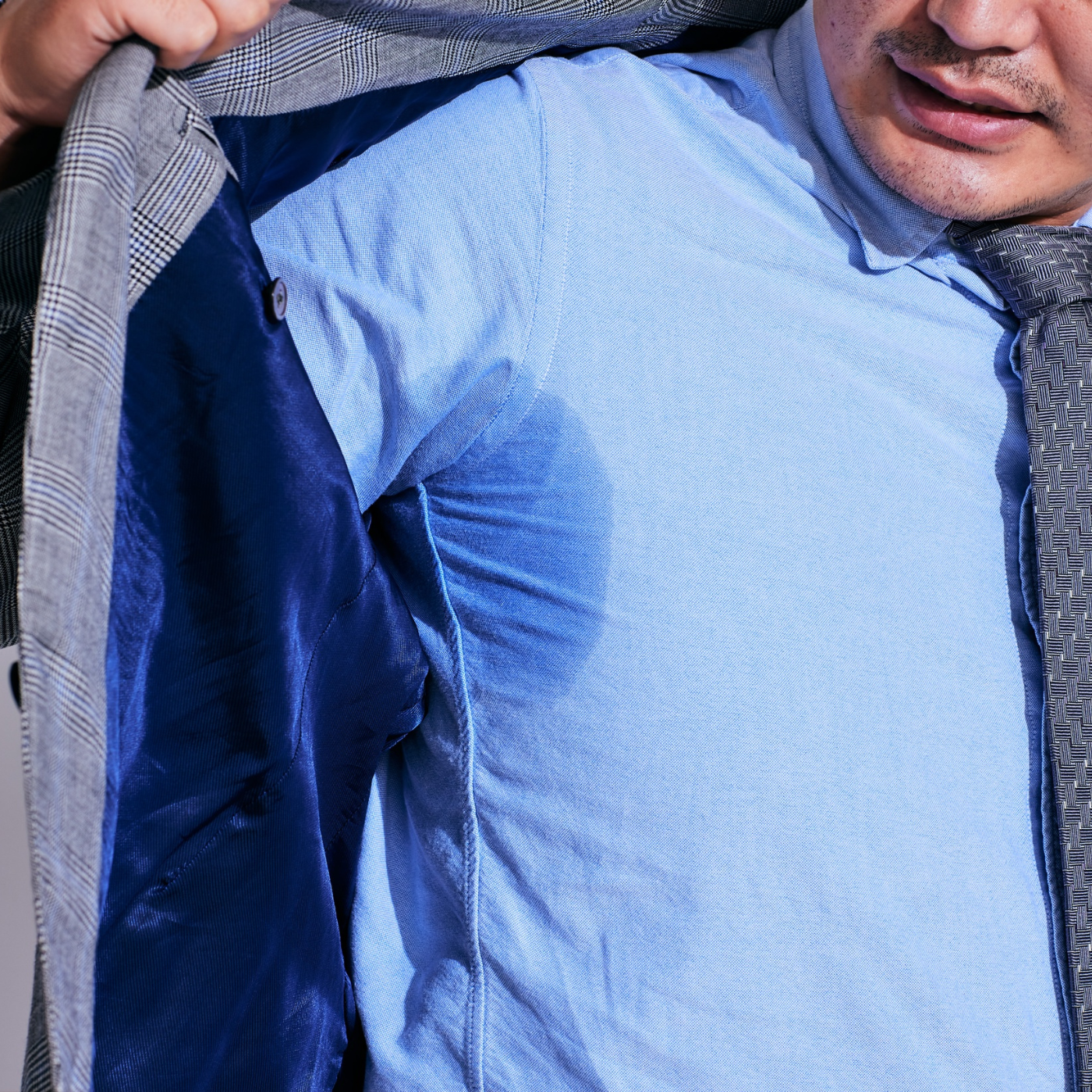 Mann mit Schweiß-Fleck auf dem Hemd