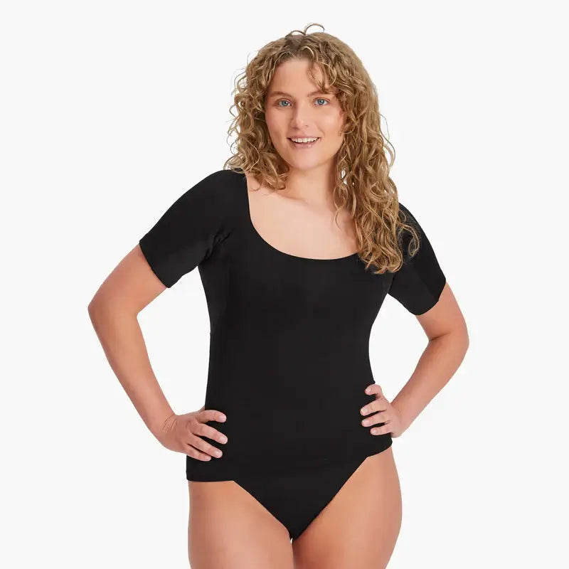 Glückliche Frau trägt schwarzes Anti-Schweiß Shirt in Größe M. 100% Schutz vor Schweißflecken. Shirt aus weicher Lenzing Modal-Faser. Zeigt stolz schweißfreie Achseln für mehr Selbstbewusstsein. #farbe_schwarz