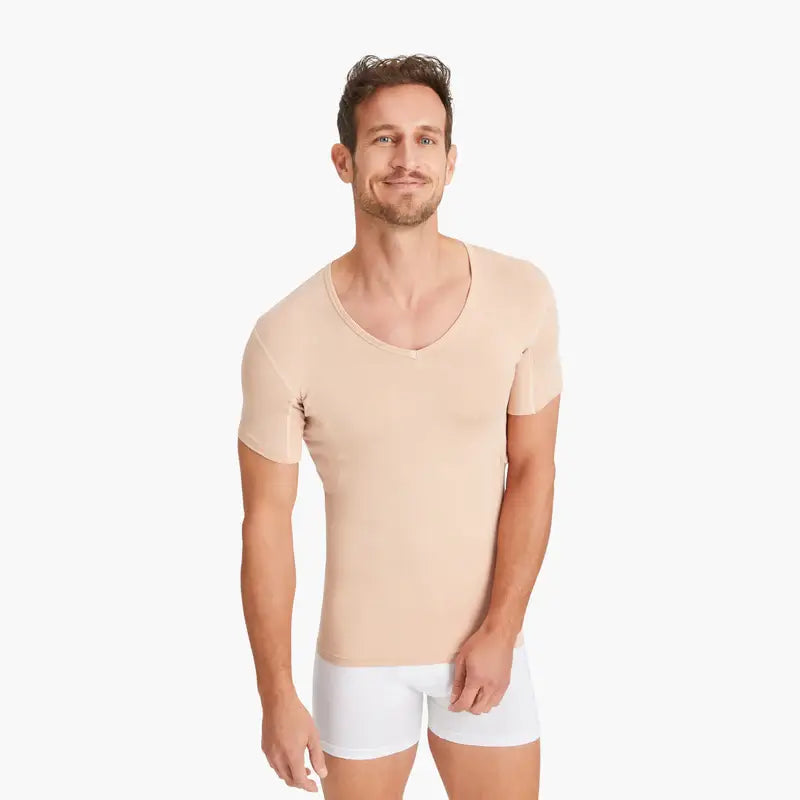 Zufriedener Mann trägt beiges Anti-Schweiß-Shirt mit V-Ausschnitt in Größe M. 100% Schutz vor Schweißflecken dank innovativer 3-Lagen-Technologie. Weicher, atmungsaktiver Stoff für optimalen Komfort.#farbe_nude