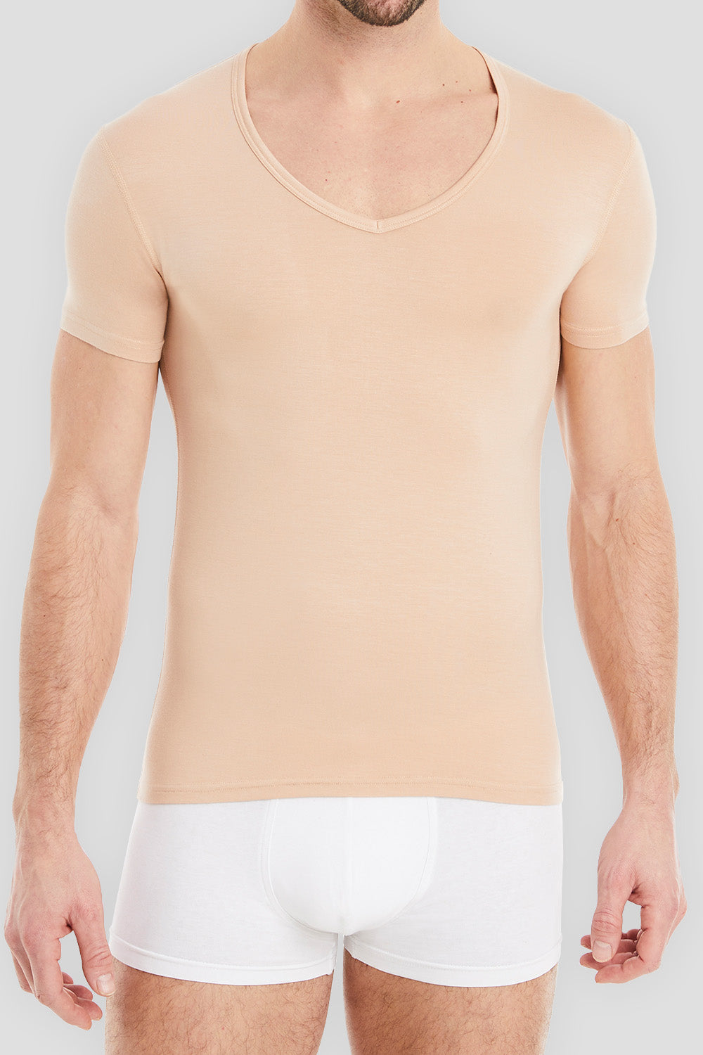 Modell präsentiert klassische Business-Unterhemden für Herren. Stilvoll und professionell - perfekt für jeden Anlass.