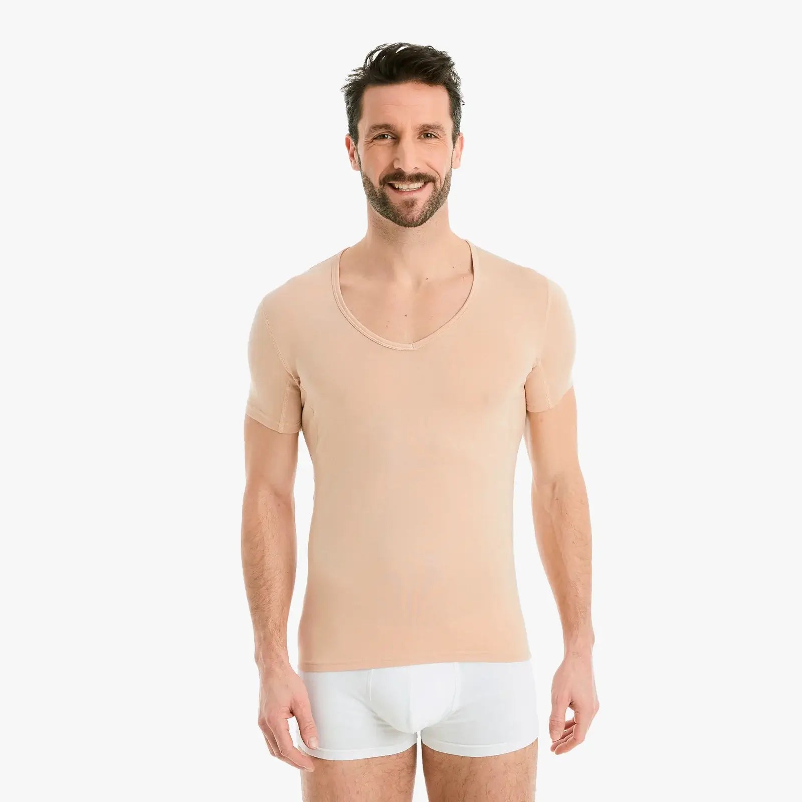 Selbstbewusster Mann lächelt in nude Funktionsunterhemd Herren mit Einsätzen. Reduziert Schweißflecken, Slim-Fit Schnitt, hoher Tragekomfort. #farbe_nude