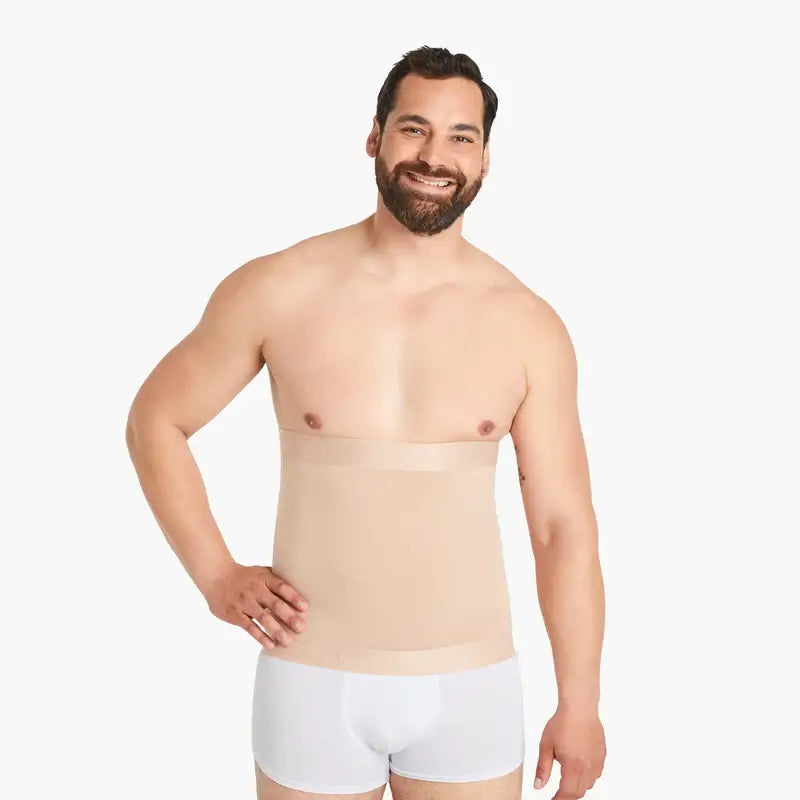 Ein Mann mit hautfarbenem Shapewear Kompressions-Gürtel, lacht selbstbewusst in die Kamera, eine Hand in die Hüfte gestemmt. Mit extra starkem Kompressionseffekt, hochwertiger Baumwolle. #farbe_nude