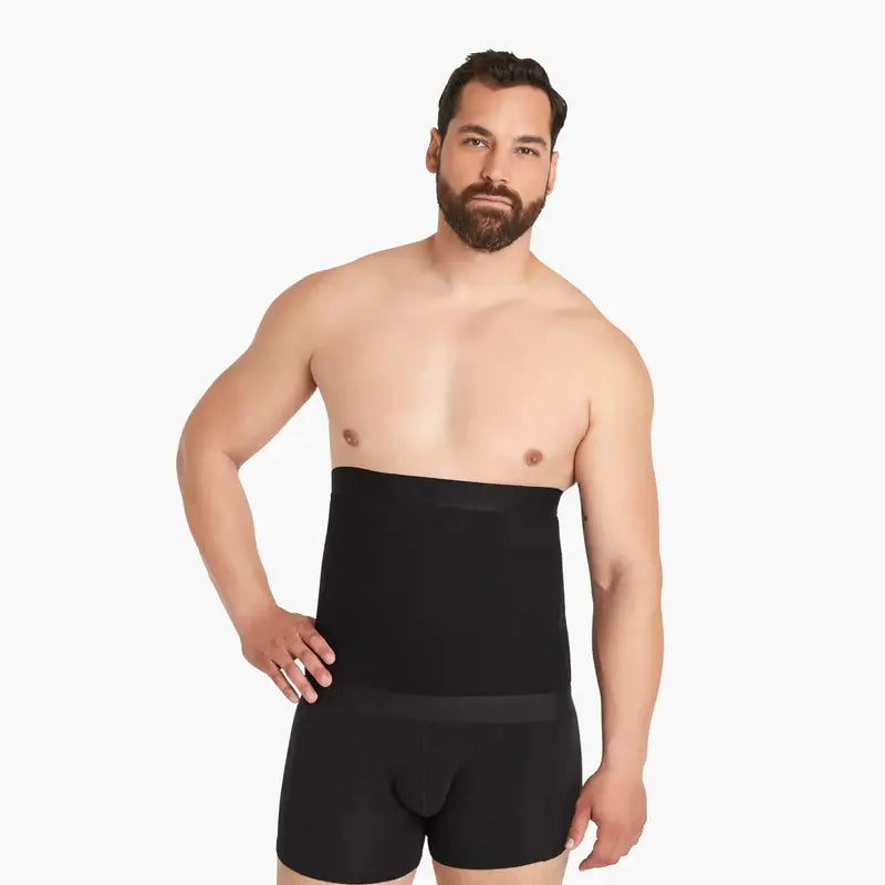 Ein Mann mit einem schwarzen Shapewear Kompressions-Gürtel, schaut selbstbewusst in die Kamera, eine Hand in die Hüfte gestemmt. Gürtel mit extra starken Kompressionseffekt, hochwertige Baumwolle. #farbe_schwarz