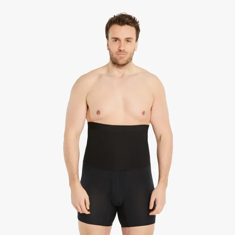 Ein selbstbewusster Mann trägt schwarze Shapewear Kompressions-Shorts und schaut direkt in die Kamera. Seine Arme sind entspannt an der Seite. Die Shorts bieten einen extra starken Kompressionseffekt und bestehen aus hochwertiger Baumwolle für Tragekomfort. #farbe_schwarz
