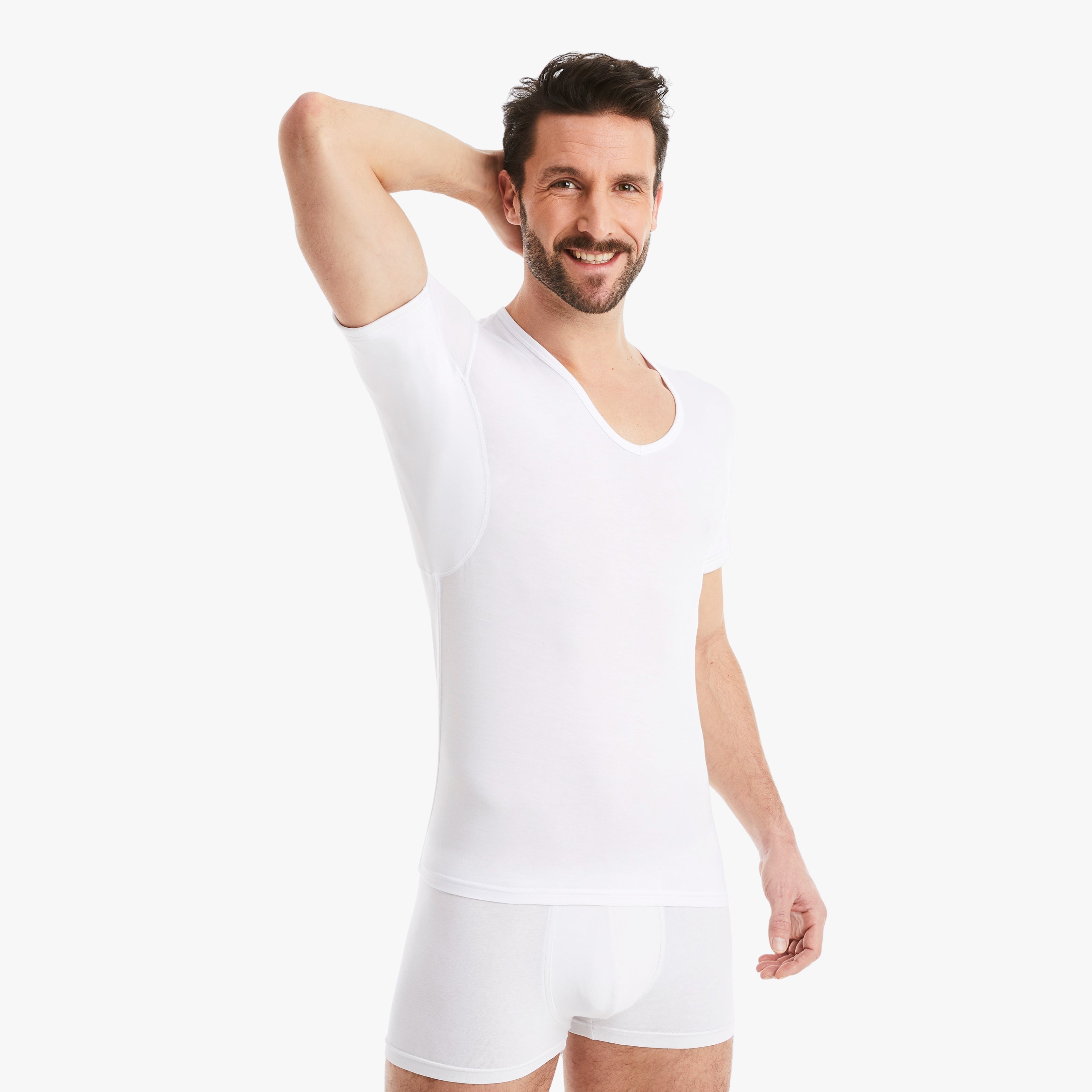 Zufriedener Mann trägt weißes Anti-Schweiß Unterhemd Herren mit V-Abschnitt in Größe M. 100% Schutz vor Schweißflecken. Zertifizierter Tragekomfort. Zeigt stolz schweißfreie Achseln. #farbe_weiß