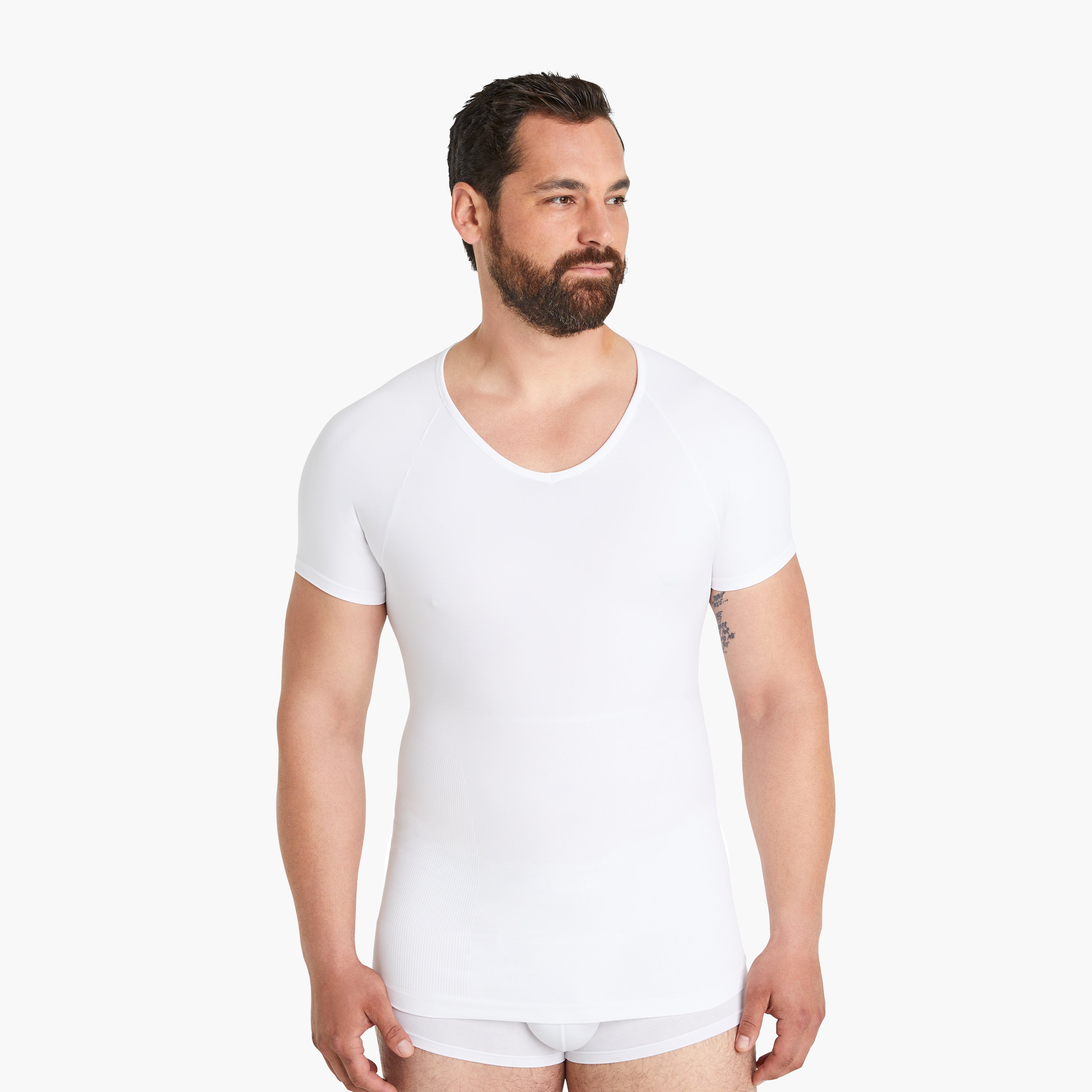 Selbstbewusster und zufriedener Mann trägt Größe XL des Seamless Shapewear Unterhemds für Herren. Entdecken Sie Komfort und Unterstützung in unserem weißen Kurzarm-Kompressionsshirt. #farbe_weiß