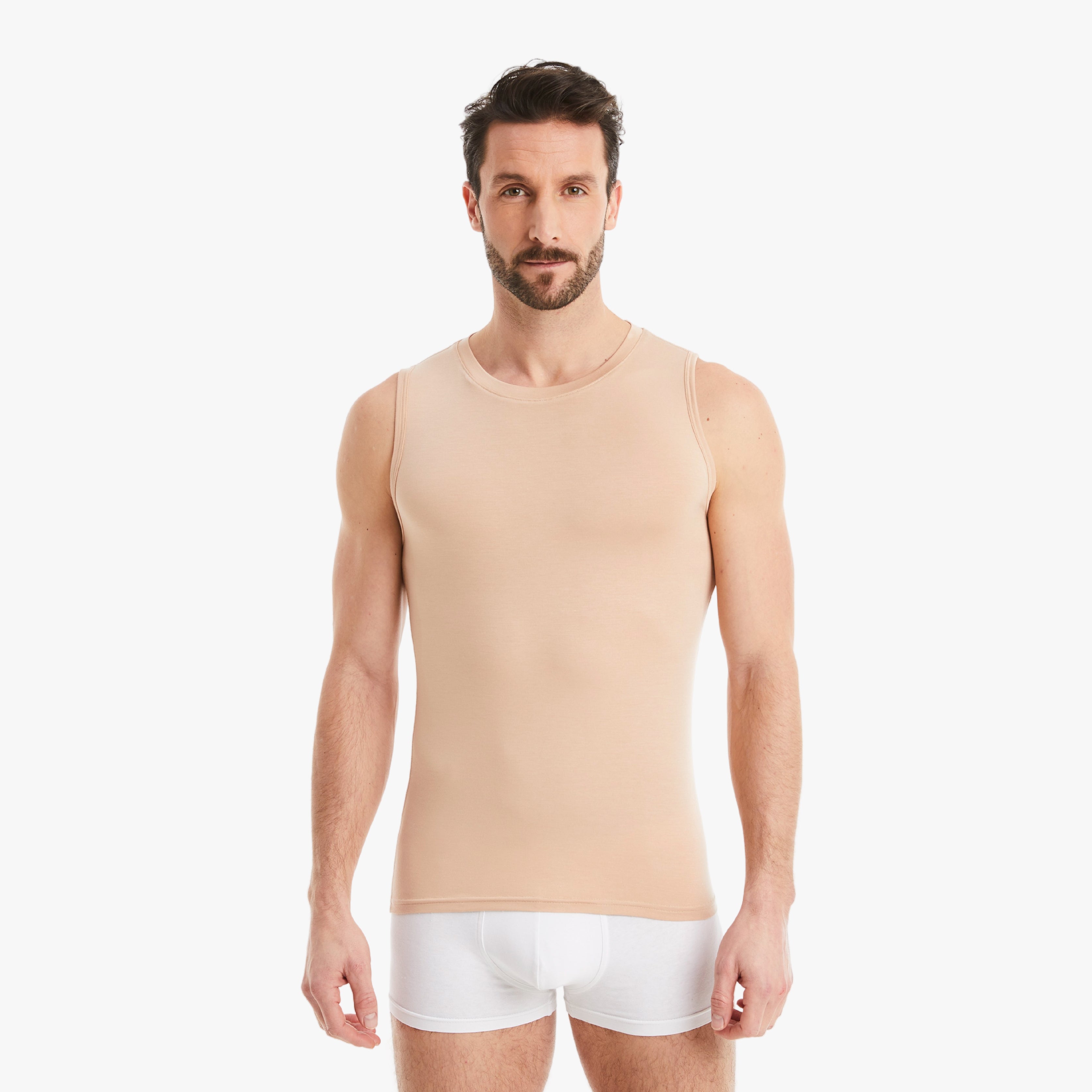 Selbstbewusster Mann mit nude Herren Unterhemd Ärmellos/Rundhals. Aus Micro-Modal Stoff, Slim-Fit für maximalen Tragekomfort. #farbe_nude